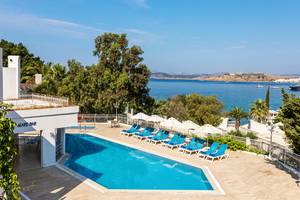 Pool mit Liegestühlen und Sonnenschirmen im LABRANDA TMT Bodrum Hotel