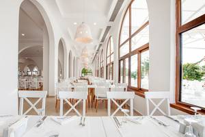 Innenbereich des LABRANDA TMT Bodrum Restaurants mit vielen weißen Tischen und Stühlen.