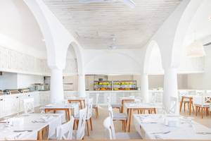 Innenraum des LABRANDA TMT Bodrum Restaurants mit weißen Tischen und Stühlen.