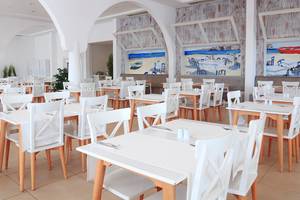 Foto des Restaurant-Innenbereichs des LABRANDA TMT Bodrum mit weißen Tischen und Stühlen.