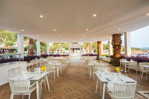 Innenansicht des LABRANDA TMT Bodrum Hotels mit vielen weiß gedeckten Tischen und Stühlen im Freien.