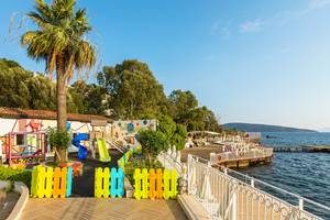 Außenbereich des LABRANDA TMT Bodrum Hotels mit buntem Kinderspielplatz am Wasser
