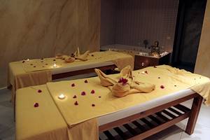 Behandlungsraum im LABRANDA TMT Bodrum Hotel mit zwei Massagebetten, gelb lackierten Wänden und einem Buddha-Standbild.