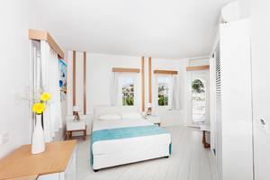 Ein modernes Schlafzimmer im LABRANDA TMT Bodrum Hotel mit einem Bett, Blumenvase und Blick auf die Stadt.