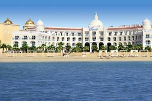Außenansicht des KaiSol Romance Resort Sahl Hasheesh mit weißem Gebäude und goldenen Kuppeln.