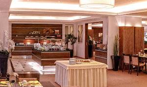 Restaurant im Hamburg Mitte Hotel mit vielen Tischen und Stühlen, dekoriert mit Pflanzen und Lampen.