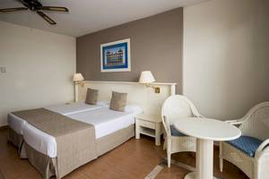 Doppelbett-Zimmer im Bahia Principe Sunlight Costa Adeje Hotel mit Nachttischen, Stühlen und Gemälde.