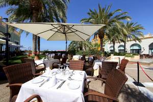 Gartenrestaurant im Bahia Principe Sunlight Costa Adeje Hotel mit Sonnenschirmen und Palmen