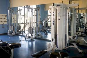 Fitnessstudio im Hotel Bahia Principe Sunlight Costa Adeje mit verschiedenen Trainingsgeräten und Spiegeln.