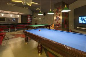 Pool-Lounge im Maxx Royal Belek Golf Resort mit zwei Billardtischen und Fernseher.