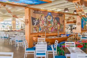 Innenansicht des Restaurants im H10 Suites Lanzarote Gardens mit buntem Wandbild und gedeckten Tischen.