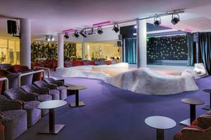 Loungebereich im H10 Suites Lanzarote Gardens mit weißen Möbeln und violettem Boden.