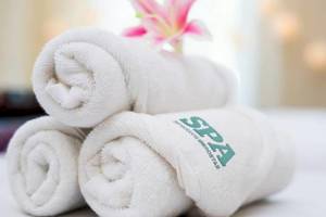 Drei weiße Handtücher mit der Aufschrift SPA auf einem Hotelbett im Iberostar Malaga Playa.