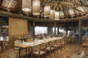 Innenansicht des Restaurants Recif Attitude mit Holztischen, Stühlen und Holzdecke.