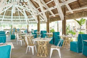 Innenbereich des Recif Attitude Restaurants mit blauen und weißen Stühlen und Tischen.