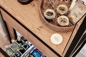 Minibar im Blue Palace Resort & Spa mit Getränken, Snacks und einem weißen Etikett.