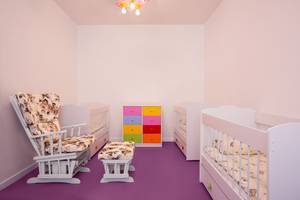 Kinderzimmer im IC Santai Family Resort mit rosa Wänden, violettem Boden und bunten Möbeln.