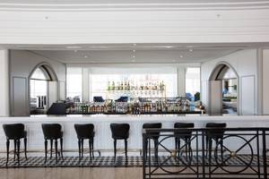 Barbereich des IC Santai Family Resorts mit vielen Getränken und schwarzen Stühlen.