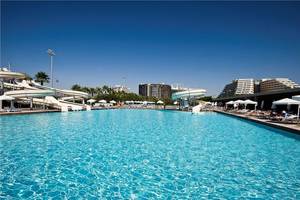 Außenpool des Nirvana Cosmopolitan Hotels mit Wasserrutschen und Sonnenliegen.