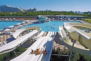 Wasserrutschen im Nirvana Cosmopolitan Hotel mit Schwimmbad und Palmen im Hintergrund.