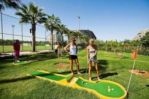Zwei Frauen spielen Golf im Nirvana Cosmopolitan Hotelgarten.