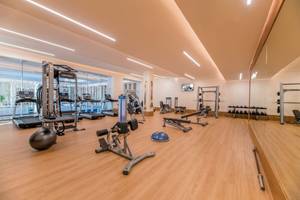 Fitnessstudio im Haven Riviera Cancun Resort & Spa mit Geräten und Spiegeln.