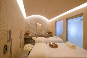 Massageraum im Haven Riviera Cancun Resort & Spa mit zwei Behandlungstischen und einem Waschbecken.
