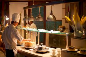 Koch im Restaurant des Constance Halaveli Maldives, der Gerichte zubereitet
