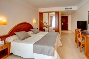 Hotelzimmer im Hipotels Natura Palast mit zwei Betten, Fernseher und Schreibtisch.