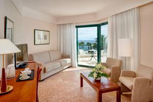Innenansicht des Hipotels Natura Palace Suite Zimmers mit Meerblick und Wohnzimmermöbeln.