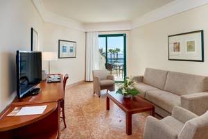 Wohnzimmer des Hipotels Natura Palace mit Sofa, Tisch, Fernseher und Meerblick