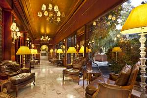 Innenansicht des Palmeraie Palace Hotels mit Lederstühlen und Kronleuchtern.