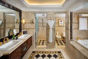 Badezimmer im Beach Rotana Hotel mit zwei Waschbecken, Badewanne und Dusche.