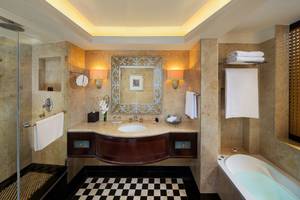 Badezimmer im Beach Rotana Hotel mit Badewanne, Dusche und Waschbecken.