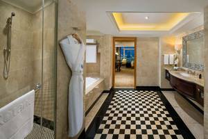 Badezimmer im Beach Rotana Hotel mit Badewanne, Dusche, Waschbecken und Marmorboden.