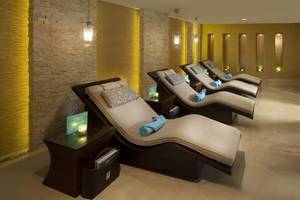 Spa-Lounge-Sessel im Beach Rotana Hotel, geordnet in einer Reihe mit Beistelltischen.