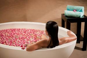 Frau im Badewann mit Blumen im Beach Rotana