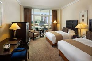 Zimmer im Beach Rotana Hotel mit zwei Betten und Meerblick.