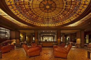 Palmeraie Palace Lobby mit Ledersesseln und farbiger Glaskuppel.