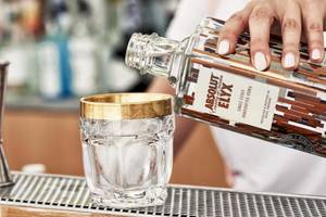 Ein Barkeeper im Myconian Korali Hotel gießt einen Cocktail in ein Glas.