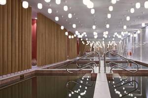 Innenpool des Myconian Korali Relais & Chateaux mit hängenden Lampen und Holzwänden
