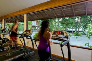 Fitnessraum im Barefoot Eco Hotel mit mehreren Läufern auf Laufbändern und großer Fensterfront.