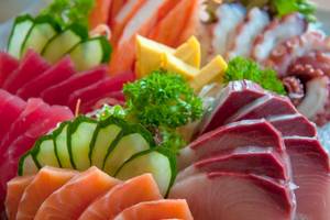 Eine Auswahl verschiedener Fischplatten, einschließlich Thunfisch, Lachs und Tintenfisch, auf Eis serviert.