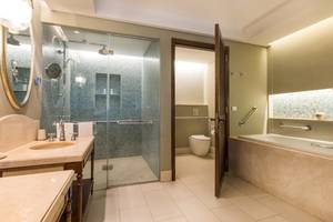 Badezimmer im JW Marriott Mauritius Resort mit Regendusche und Badewanne.