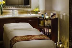 Luxuriöser Spa-Behandlungsraum im Palace At One & Only Royal Mirage mit Massageliege, Waschbecken und Kosmetikprodukten.