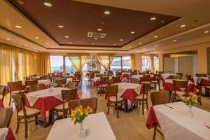 Innenansicht des Restaurants im Astir Beach Hotel in Zakynthos mit vielen gedeckten Tischen und Stühlen.