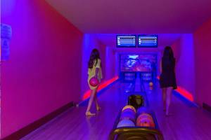 Zwei Frauen spielen Bowling auf der Bowlingbahn des Royal Holiday Palace Hotels.