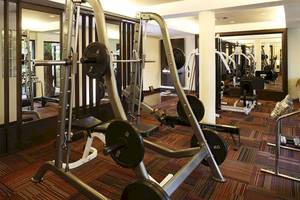 Fitnesscenter im Cape Panwa Hotel mit verschiedenen Geräten wie Hanteln und Laufbändern.