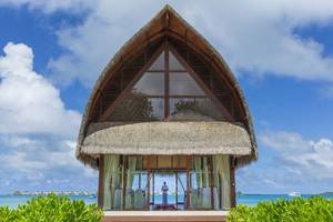 Hochzeitszeremonie im Angsana Velavaru vor dem Meer mit einer Person im Hintergrund.