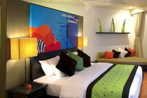 Hotelzimmer im Angsana Velavaru mit großen Gemälden, bequemem Bett und Sofa